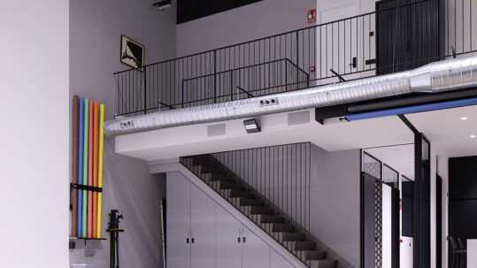 Ciclorama con office-cocina integrado y acceso a la galería superior en Estudio Equilátero, Las Rozas de Madrid.