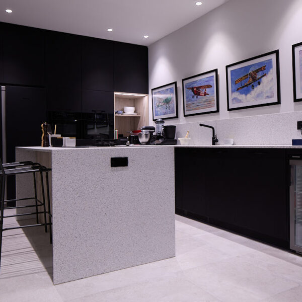 Office-cocina totalmente equipada con isla central, electrodomésticos y zona de descanso de Estudio Equilátero en Las Rozas de Madrid.