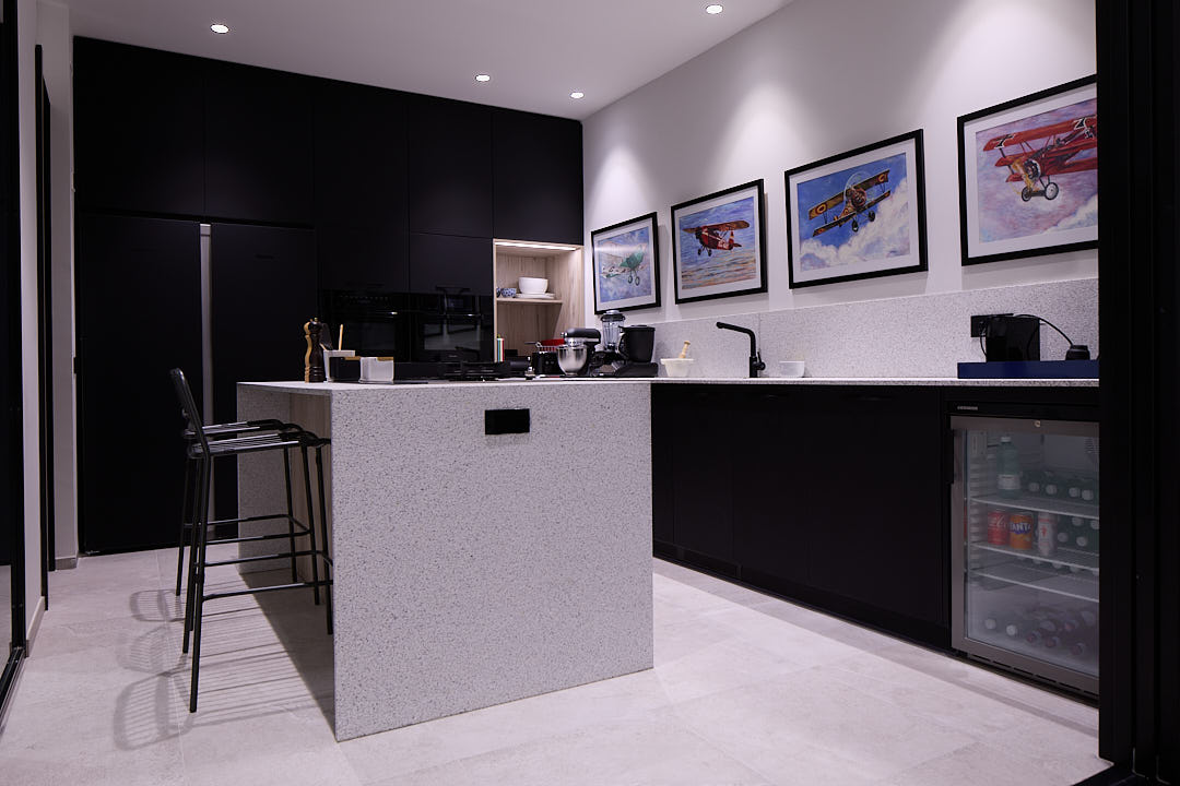 Office-cocina totalmente equipada con isla central, electrodomésticos y zona de descanso de Estudio Equilátero en Las Rozas de Madrid.
