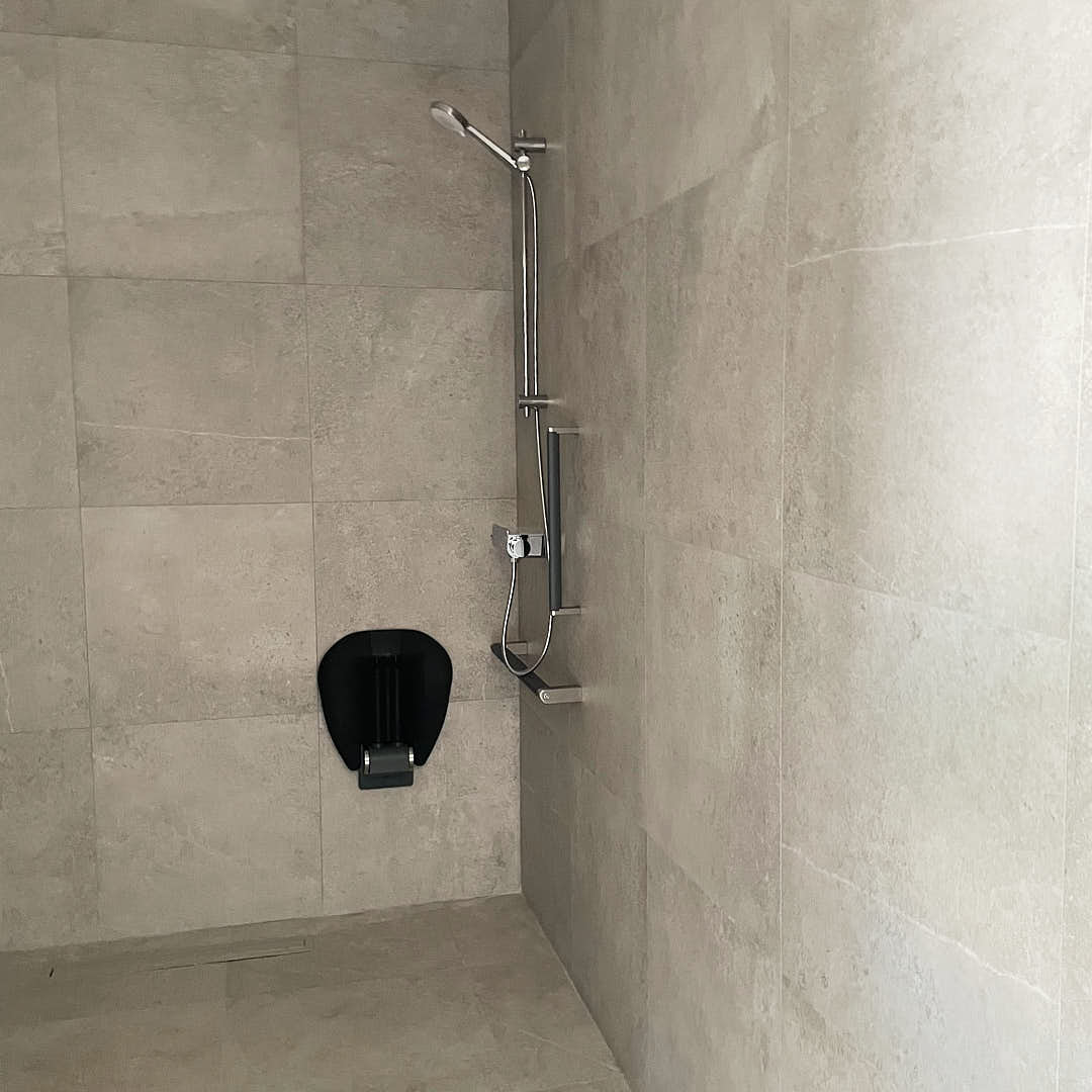 Ducha adaptada para personas con movilidad reducida en el cuarto de baño accesible de Estudio Equilátero.
